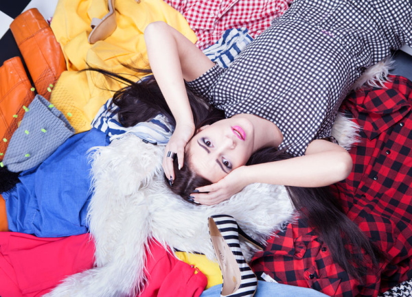 39092419 - stressed young woman lying down on a pile of clothes