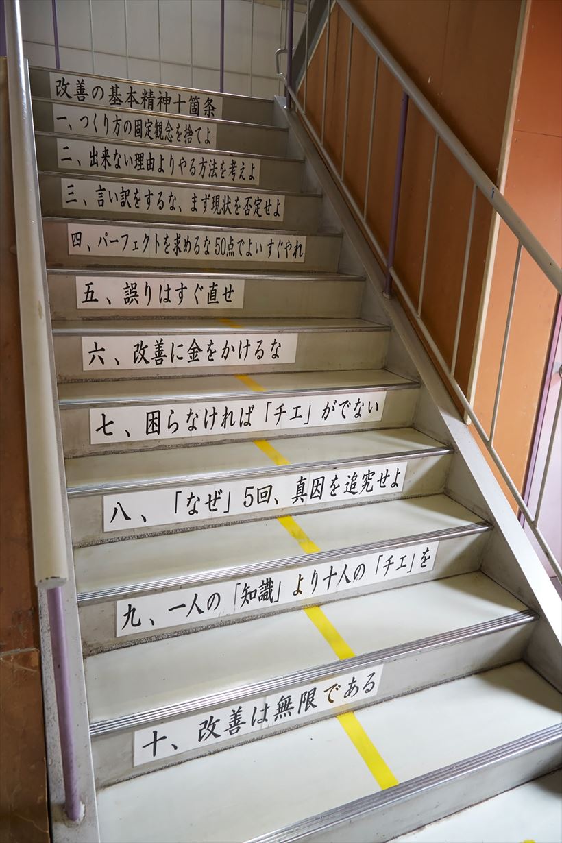 ↑工場1階と2階をつなぐ階段。一段一段に同社の「改善の基本精神十箇条」が掲示されています