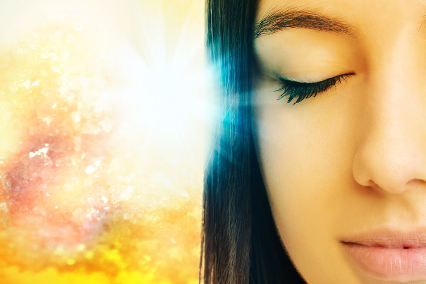 59199205 - macro close up of young woman meditating with eyes closed.conceptual spiritual background with light beam.