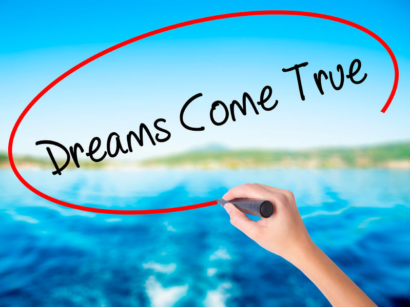65142161 - woman hand writing dreams come true on blank transparent board with a marker isolated over water background. business concept. stock photo