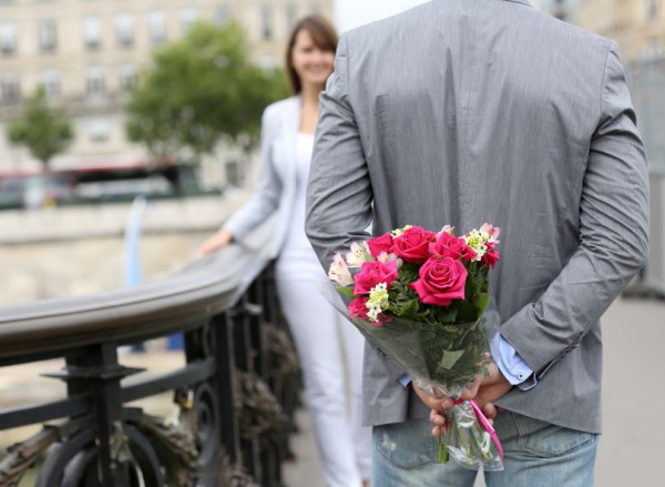 14679358 - man ready to give flowers to girlfriend on a bridge