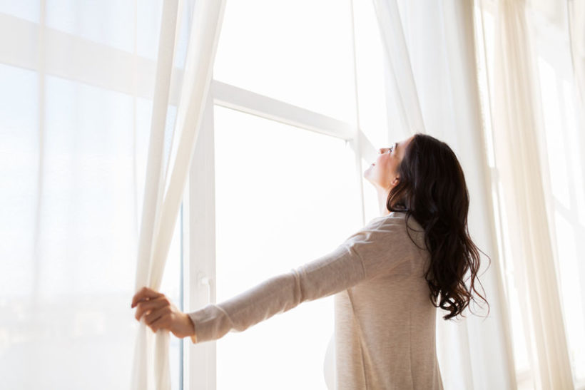 63688392 - pregnancy, motherhood, people and expectation concept - close up of happy pregnant woman opening window curtains